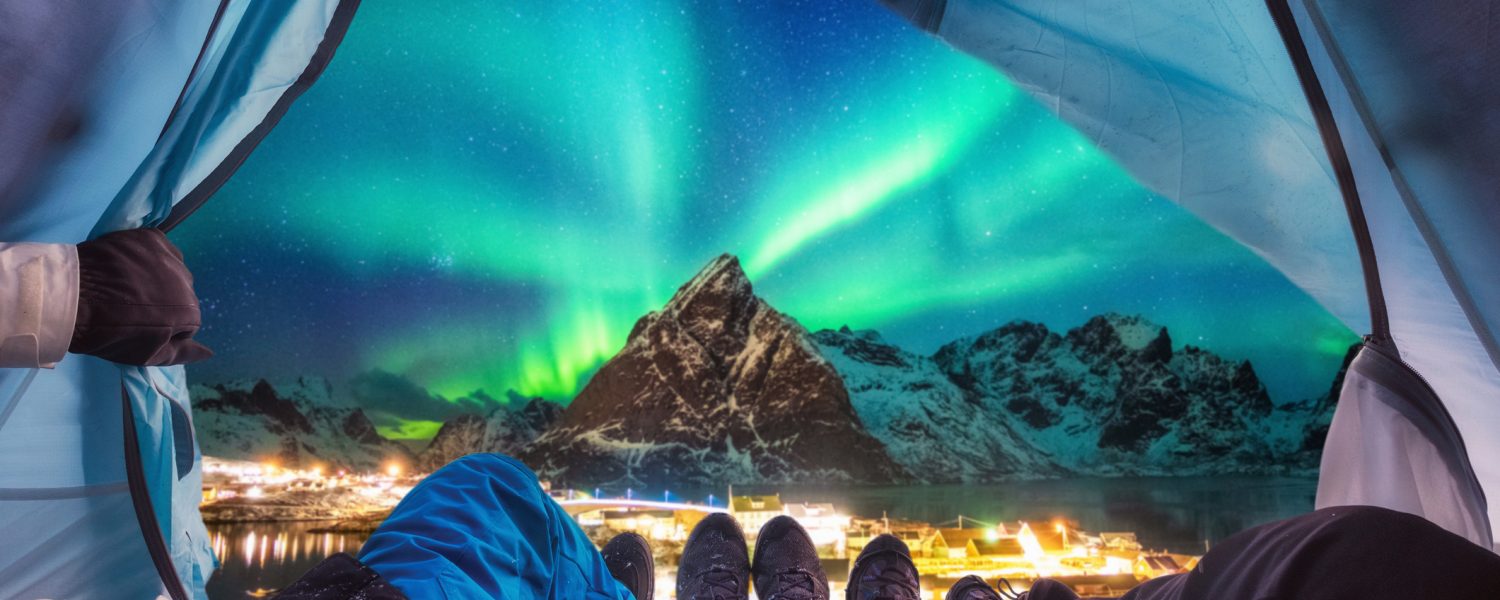Group of climber are inside camping with aurora borealis over mountain at Sakrisoy village